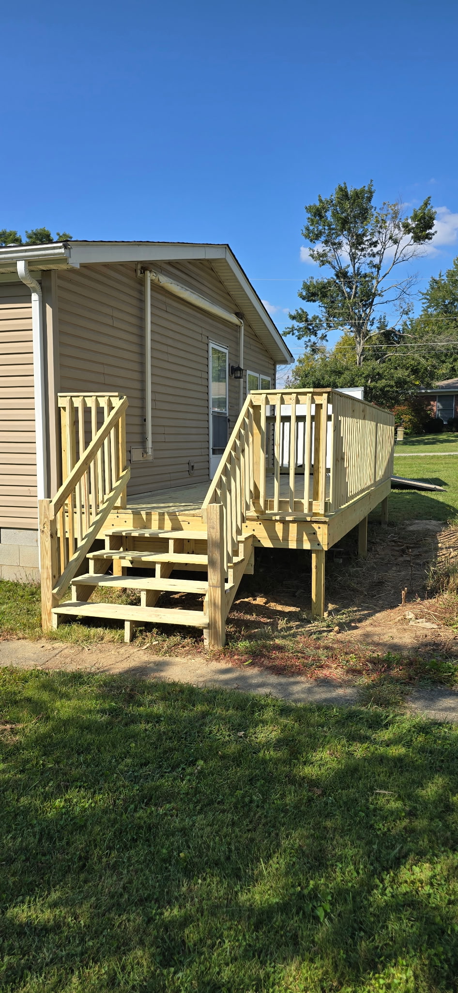Newly built wooden deck and stairs on the back of a home