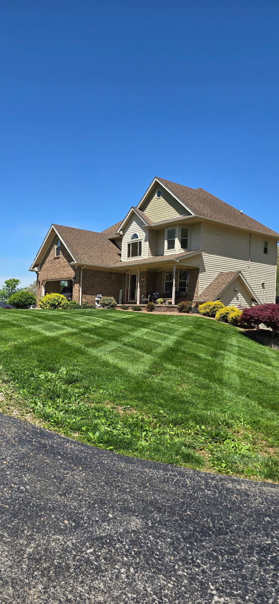 Two-story Southern Indiana home with a freshly mowed and striped lawn